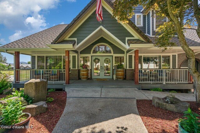 740 N Dundee Dr, Post Falls, ID 83854 - view of front of house with covered porch, french doors, brick siding, and roof with shingles