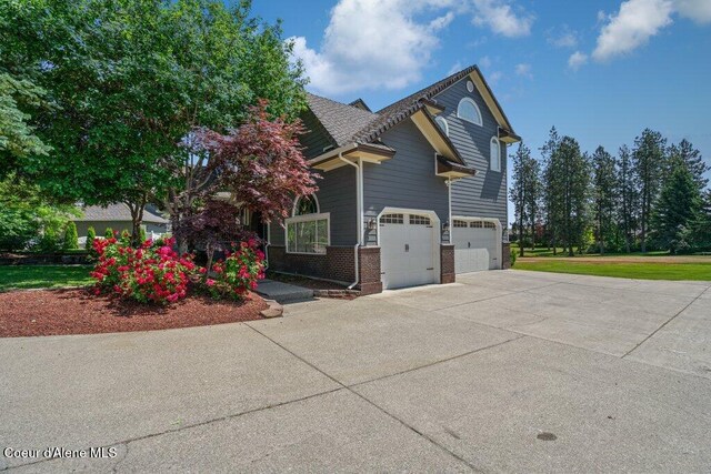 740 N Dundee Dr, Post Falls, ID 83854 - view of side of home with driveway, brick siding, and a garage