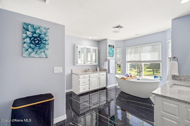 740 N Dundee Dr, Post Falls, ID 83854 - bathroom with two vanities, a freestanding bath, and recessed lighting