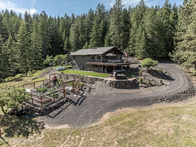 8718 W Sausser Dr, Coeur Dalene, ID 83814 - back of property featuring a wooded view, a wooden deck, and a yard