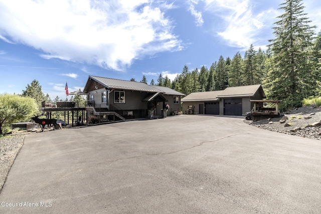 8718 W Sausser Dr, Coeur Dalene, ID 83814 - view of front of home with a metal roof, stairway, a garage, and an outbuilding