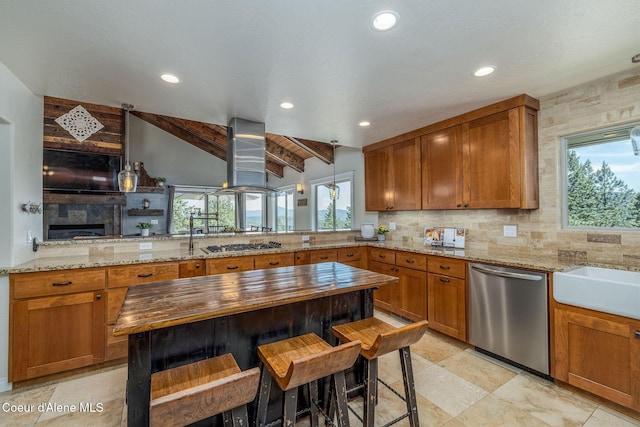 8718 W Sausser Dr, Coeur Dalene, ID 83814 - kitchen with stainless steel appliances, island exhaust hood, butcher block counters, brown cabinets, and tasteful backsplash