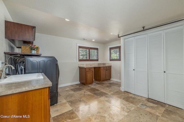 8718 W Sausser Dr, Coeur Dalene, ID 83814 - washroom with stone tile floors, washer / dryer, recessed lighting, and cabinet space