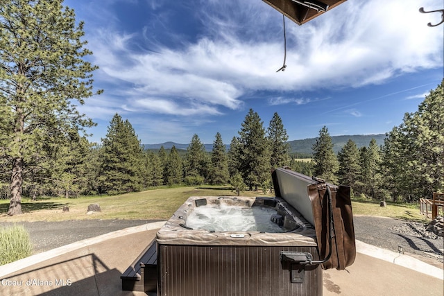 8718 W Sausser Dr, Coeur Dalene, ID 83814 - deck with a hot tub, a mountain view, and a wooded view