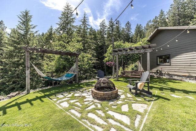 8718 W Sausser Dr, Coeur Dalene, ID 83814 - view of green lawn featuring an outdoor fire pit and a pergola