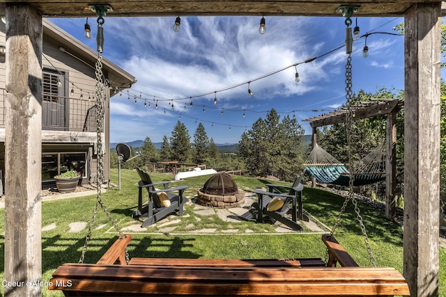 8718 W Sausser Dr, Coeur Dalene, ID 83814 - view of green lawn with a fire pit and a mountain view