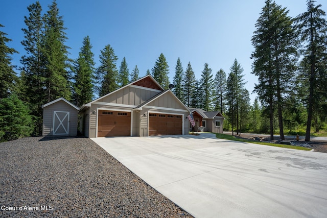 80 Parkland Dr, Blanchard, ID 83804 - view of front of house with board and batten siding, driveway, a garage, and a storage shed