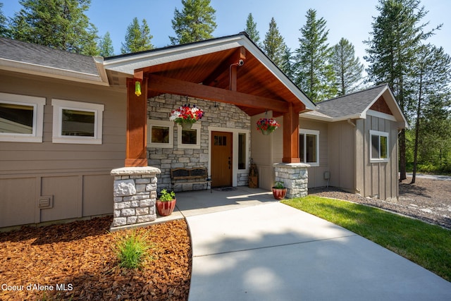80 Parkland Dr, Blanchard, ID 83804 - view of exterior entry with board and batten siding, stone siding, and roof with shingles