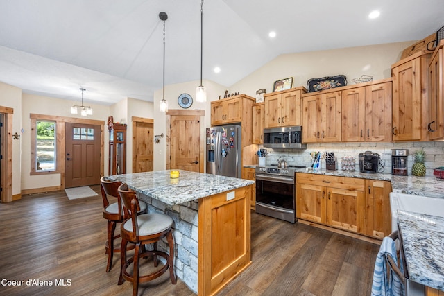 80 Parkland Dr, Blanchard, ID 83804 - kitchen with appliances with stainless steel finishes, dark wood-style flooring, tasteful backsplash, a kitchen island, and vaulted ceiling