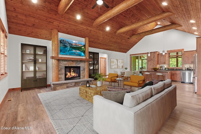 357 Odonnell Dr, Dover, ID 83825 - living area with high vaulted ceiling, a wooden ceiling with exposed beams, a ceiling fan, a stone fireplace, and light wood-type flooring
