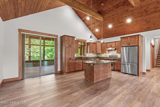 357 Odonnell Dr, Dover, ID 83825 - kitchen featuring appliances with stainless steel finishes, under cabinet range hood, dark countertops, high vaulted ceiling, and a kitchen island