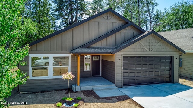 233 Jasper Loop, Ponderay, ID 83852 - view of front facade featuring a garage, driveway, a shingled roof, and board and batten siding