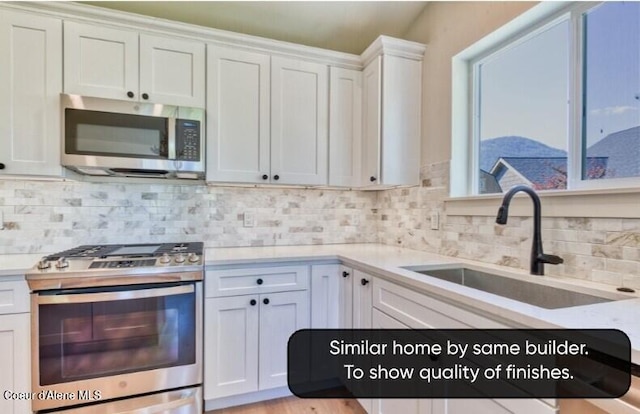 233 Jasper Loop, Ponderay, ID 83852 - kitchen featuring stainless steel appliances, light countertops, white cabinets, and backsplash
