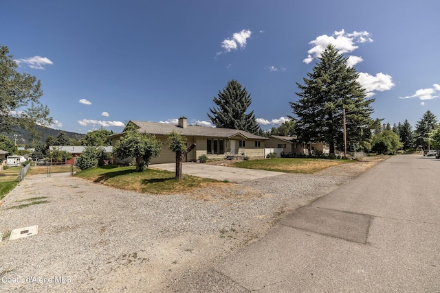 6300 N Sunrise Ter, Coeur Dalene, ID 83815 - ranch-style house with gravel driveway, a chimney, a gate, and an attached garage