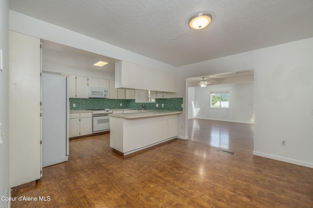 6300 N Sunrise Ter, Coeur Dalene, ID 83815 - kitchen featuring white appliances, a peninsula, dark wood finished floors, light countertops, and open floor plan