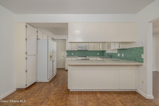 6300 N Sunrise Ter, Coeur Dalene, ID 83815 - kitchen with white appliances, light countertops, dark wood finished floors, a peninsula, and tasteful backsplash
