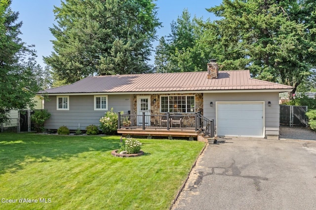 709 E 14th Ave, Post Falls, ID 83854 - ranch-style house featuring a garage, a chimney, asphalt driveway, a metal roof, and a wooden deck
