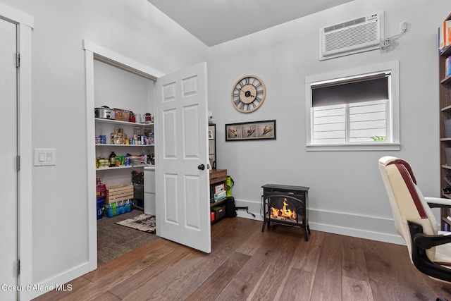 709 E 14th Ave, Post Falls, ID 83854 - office space featuring wood finished floors, a wall unit AC, and a wood stove