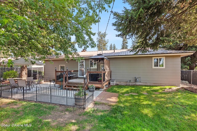 709 E 14th Ave, Post Falls, ID 83854 - rear view of property featuring a deck, a metal roof, and a patio