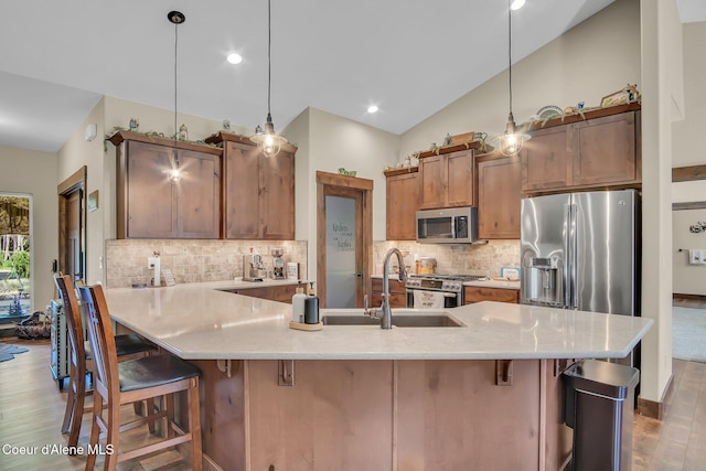 20770 N Penobscot Rd, Rathdrum, ID 83858 - kitchen with dark wood finished floors, stainless steel appliances, a breakfast bar area, tasteful backsplash, and hanging light fixtures