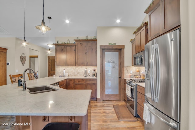 20770 N Penobscot Rd, Rathdrum, ID 83858 - kitchen with appliances with stainless steel finishes, light wood-style floors, tasteful backsplash, pendant lighting, and recessed lighting