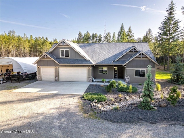 20770 N Penobscot Rd, Rathdrum, ID 83858 - craftsman-style home with board and batten siding, driveway, stone siding, and roof with shingles