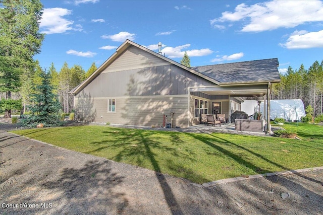 20770 N Penobscot Rd, Rathdrum, ID 83858 - back of house with a patio area, a lawn, and a shingled roof