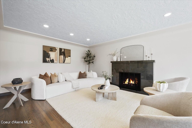1217 E Montana Ave, Coeur Dalene, ID 83814 - living area with a textured ceiling, dark wood finished floors, a tiled fireplace, and recessed lighting