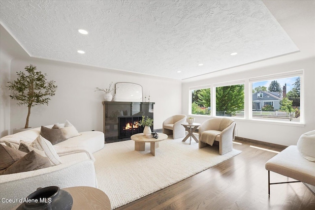 1217 E Montana Ave, Coeur Dalene, ID 83814 - living room featuring a textured ceiling, wood finished floors, a fireplace with flush hearth, and recessed lighting