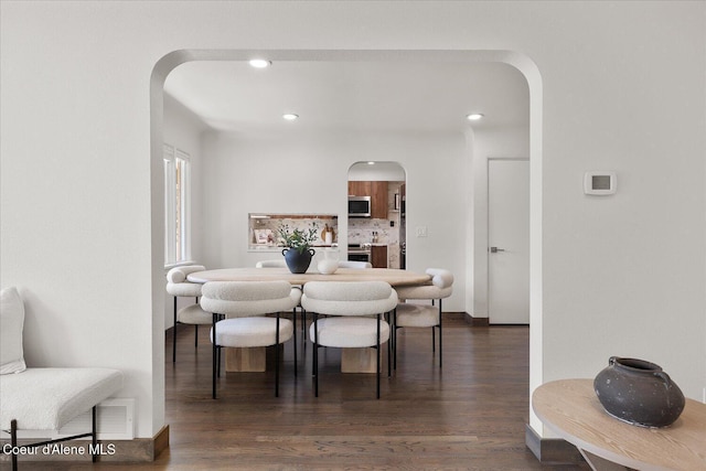 1217 E Montana Ave, Coeur Dalene, ID 83814 - dining space with arched walkways, recessed lighting, and dark wood-style floors