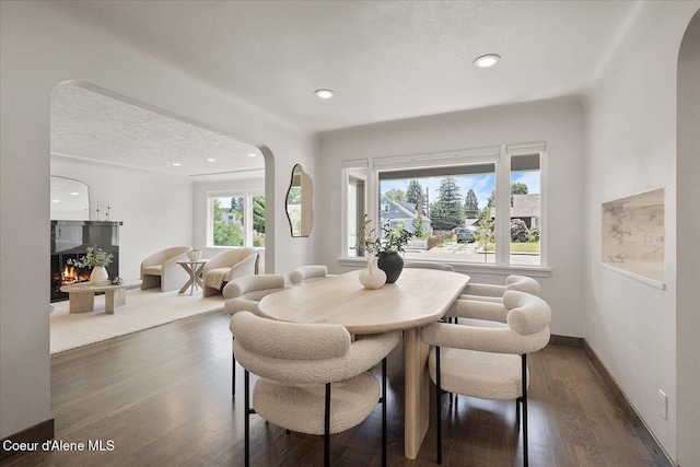 1217 E Montana Ave, Coeur Dalene, ID 83814 - dining area featuring arched walkways, dark wood-style floors, recessed lighting, and a textured ceiling