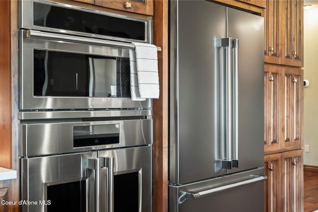 11 Canoe Cv, Dover, ID 83825 - kitchen featuring appliances with stainless steel finishes, brown cabinets, wood finished floors, and light countertops