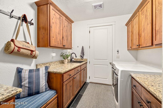 3742 W Cielo View Ct, Coeur Dalene, ID 83814 - laundry area with cabinet space, washer and clothes dryer, a textured ceiling, and dark tile patterned flooring