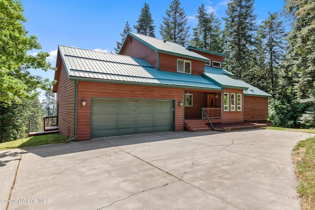 7722 W Clemetson Rd, Coeur Dalene, ID 83814 - rustic home featuring a porch, driveway, an attached garage, and a metal roof