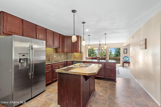 7722 W Clemetson Rd, Coeur Dalene, ID 83814 - kitchen with stainless steel appliances, a peninsula, butcher block counters, tasteful backsplash, and a center island