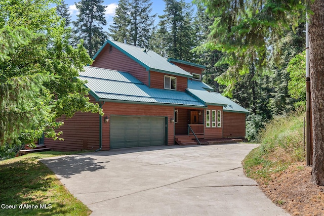 7722 W Clemetson Rd, Coeur Dalene, ID 83814 - chalet / cabin with concrete driveway, a metal roof, and an attached garage