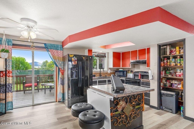1503 E 3rd Ave, Post Falls, ID 83854 - kitchen featuring black appliances, ceiling fan, light wood-type flooring, under cabinet range hood, and a center island