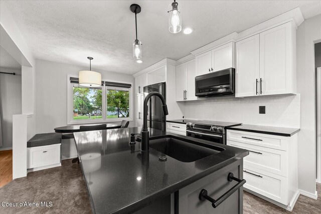502 W 14th Ave, Post Falls, ID 83854 - kitchen featuring appliances with stainless steel finishes, tasteful backsplash, white cabinets, and a textured ceiling