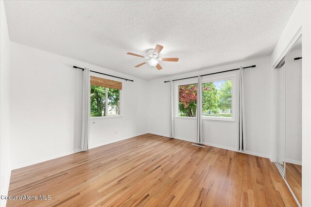 502 W 14th Ave, Post Falls, ID 83854 - spare room with light wood-type flooring, a ceiling fan, and a textured ceiling