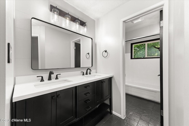 502 W 14th Ave, Post Falls, ID 83854 - bathroom featuring double vanity, a bathtub, and a textured ceiling