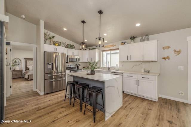 13417 N Halley St, Rathdrum, ID 83858 - kitchen with appliances with stainless steel finishes, a breakfast bar, white cabinetry, a kitchen island, and lofted ceiling