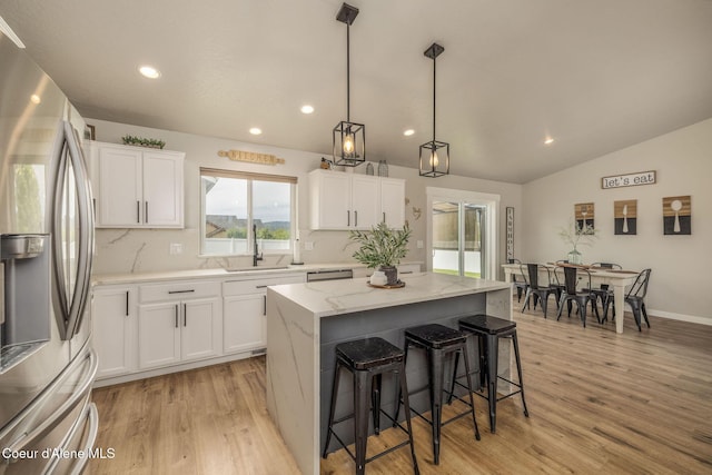 13417 N Halley St, Rathdrum, ID 83858 - kitchen featuring stainless steel fridge, recessed lighting, light wood-type flooring, a kitchen bar, and white cabinets