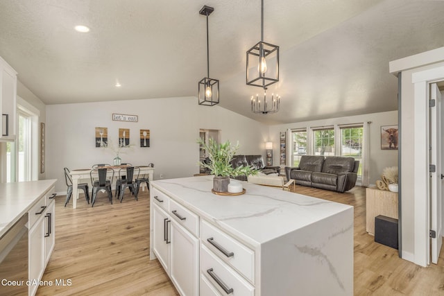 13417 N Halley St, Rathdrum, ID 83858 - kitchen featuring lofted ceiling, white cabinets, light wood-style floors, a center island, and decorative light fixtures