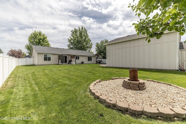 13417 N Halley St, Rathdrum, ID 83858 - rear view of house with a fire pit, a fenced backyard, and board and batten siding
