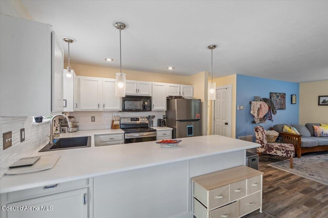 2270 W Linda Way, Post Falls, ID 83854 - kitchen featuring appliances with stainless steel finishes, a peninsula, dark wood-type flooring, light countertops, and decorative backsplash