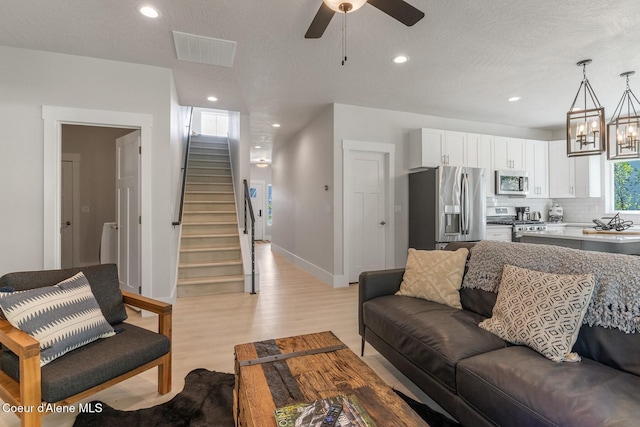 52 Peggys Ct, Dover, ID 83825 - living room with stairs, light wood finished floors, a ceiling fan, recessed lighting, and a chandelier