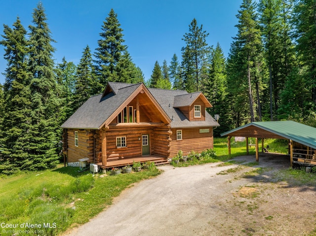 4900 E Hudlow Rd, Hayden, ID 83835 - cabin with driveway, a carport, log siding, and a view of trees