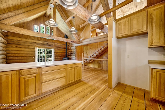 4900 E Hudlow Rd, Hayden, ID 83835 - kitchen with log walls, light countertops, light wood finished floors, a wood ceiling with exposed beams, and high vaulted ceiling