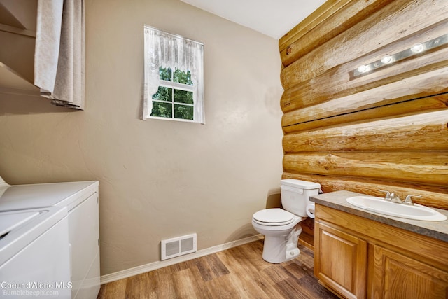 4900 E Hudlow Rd, Hayden, ID 83835 - half bathroom featuring washer and dryer, log walls, vanity, and wood finished floors