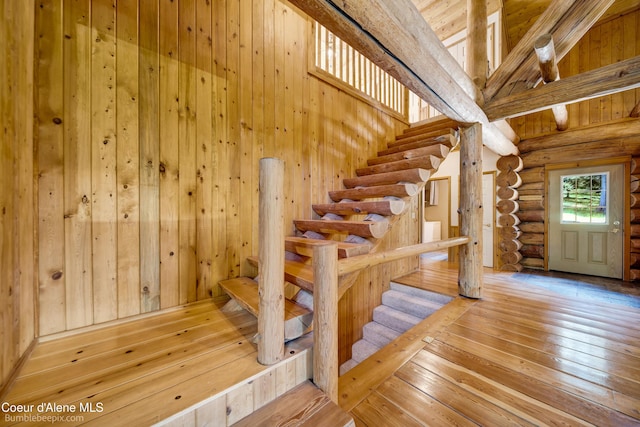 4900 E Hudlow Rd, Hayden, ID 83835 - stairs with log walls, hardwood / wood-style flooring, beam ceiling, high vaulted ceiling, and wooden walls